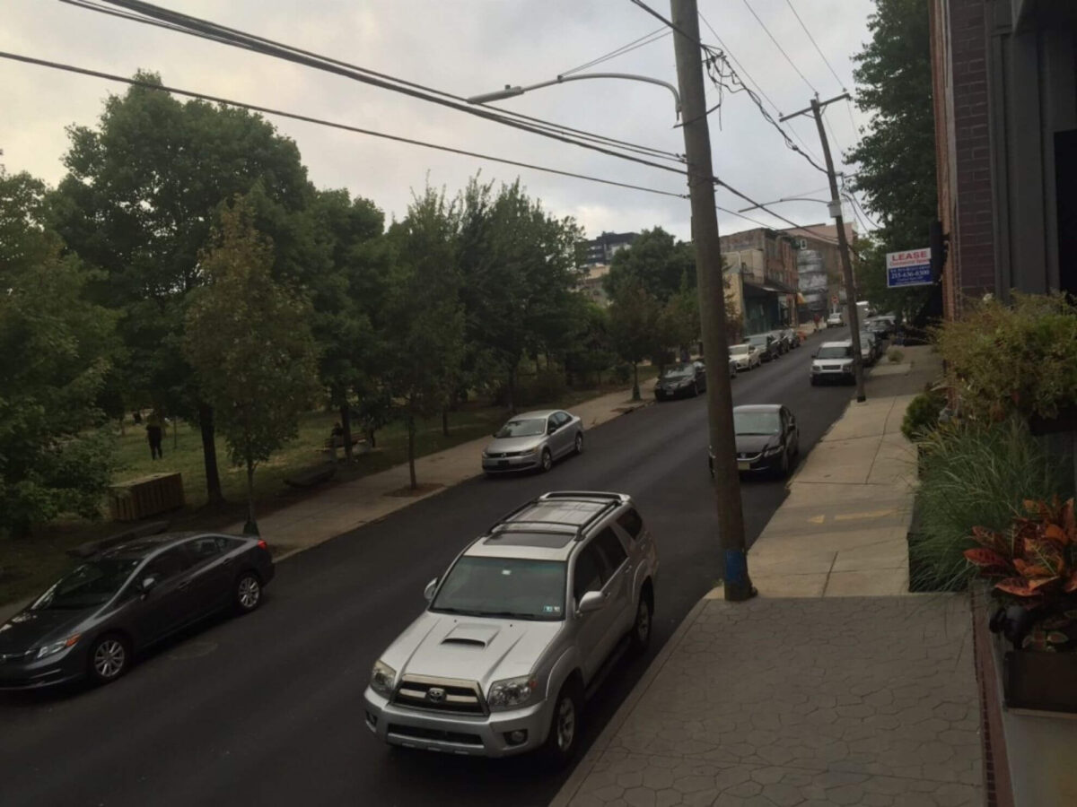 The Silence the Pope Brings - City block with parked cars and telephone poles